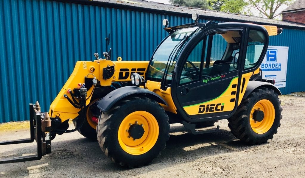 A yellow and black DIECI tractor parked in front of a building.