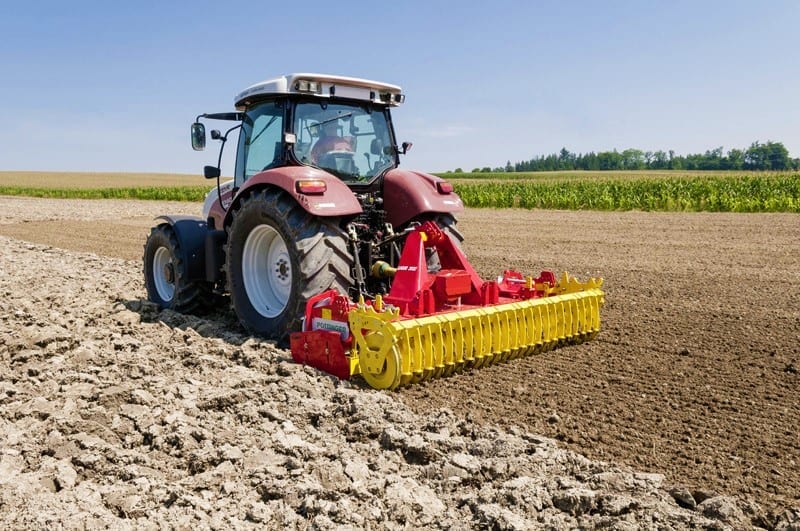 A tractor plowing a field with a plow.