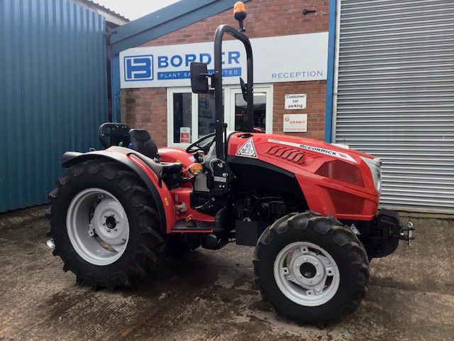 A McCormick X2-055 Tractor parked in front of a building.