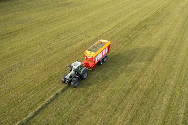 An aerial view of a Pottinger Jumbo 7000 Series Loader Wagon on a green field.